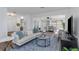 Bright living room featuring modern furniture, light wood floors, and seamless flow to kitchen and Florida room at 1432 S Keene Rd, Clearwater, FL 33756