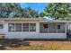The back of the house features a screened-in porch and windows, offering natural light and views of the backyard at 1432 S Keene Rd, Clearwater, FL 33756