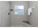 Tiled shower features a corner shelf, frosted window, and built-in bench, offering a spa-like experience at 1432 S Keene Rd, Clearwater, FL 33756