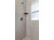 Detailed view of the updated tiled shower with a built-in shelf and seat, plus a frosted window at 1432 S Keene Rd, Clearwater, FL 33756