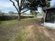 Large, grassy backyard with mature trees and wooden fence at 1542 Sherwood St, Clearwater, FL 33755