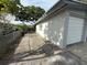 Side exterior view of home with attached garage, gravel side yard, and chain link fence at 1542 Sherwood St, Clearwater, FL 33755