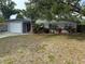Charming single story home with attached garage, red door, and tropical landscaping at 1542 Sherwood St, Clearwater, FL 33755