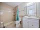 Tiled bathroom with a walk-in shower, vanity, and a decorative framed mirror at 1615 Stonehaven Way, Tarpon Springs, FL 34689