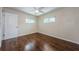 Bedroom with neutral walls, wood floors, a ceiling fan, and bright windows at 1615 Stonehaven Way, Tarpon Springs, FL 34689
