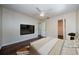 Primary bedroom with wood floors, tv, and ceiling fan in a neutral palette at 1615 Stonehaven Way, Tarpon Springs, FL 34689