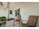 Inviting front porch area with brick flooring, two chairs, and a white front door at 1615 Stonehaven Way, Tarpon Springs, FL 34689