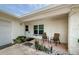 Inviting front porch featuring a seating area, decorative plants, and a textured exterior wall at 1615 Stonehaven Way, Tarpon Springs, FL 34689
