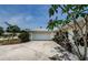 Home featuring an attached garage and a beautifully landscaped front yard with tropical foliage at 1615 Stonehaven Way, Tarpon Springs, FL 34689
