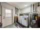 Functional laundry room with a washer, dryer, water heater, and access to the backyard at 1615 Stonehaven Way, Tarpon Springs, FL 34689