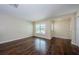 Bright living room with rich hardwood floors and natural light from the window at 1615 Stonehaven Way, Tarpon Springs, FL 34689