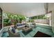 Covered patio with comfortable seating, a coffee table, and views of the lush backyard at 1615 Stonehaven Way, Tarpon Springs, FL 34689
