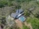 Aerial shot of a home with a screened-in pool, surrounded by trees, showcasing the private backyard oasis at 17515 Drake Ct, Lutz, FL 33559