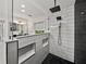Modern glass shower with black and white tile design in a stylish bathroom at 17515 Drake Ct, Lutz, FL 33559