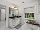 Charming bathroom featuring vanity with black countertop and fixtures, plus a soaking tub at 17515 Drake Ct, Lutz, FL 33559