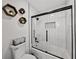 Bright bathroom featuring subway tile shower with glass door, hexagonal wall art, and modern fixtures at 17515 Drake Ct, Lutz, FL 33559