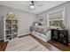 Neutral toned bedroom with a platform bed, hardwood floors, shelving, and a window at 17515 Drake Ct, Lutz, FL 33559