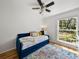 Cozy bedroom with daybed, colorful rug, hardwood floors, and natural light from the window at 17515 Drake Ct, Lutz, FL 33559