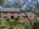 Charming brick home with black shutters, lush landscaping, and a front yard with a tree swing for outdoor enjoyment at 17515 Drake Ct, Lutz, FL 33559
