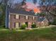 Charming two-story brick home featuring a well-manicured lawn and mature landscaping during a vibrant sunset at 17515 Drake Ct, Lutz, FL 33559