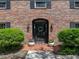 Inviting front entryway with black door, decorative wreath, and potted flowers on a brick walkway at 17515 Drake Ct, Lutz, FL 33559