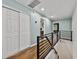 Second story hallway with blue walls, modern railing, hardwood flooring, and bedroom & bathroom access at 17515 Drake Ct, Lutz, FL 33559