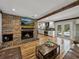 Living room featuring a brick fireplace, hardwood floors and access to the pool at 17515 Drake Ct, Lutz, FL 33559