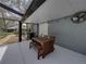 Under a screened patio is an outdoor dining area, ceiling fan and outdoor lighting at 17515 Drake Ct, Lutz, FL 33559