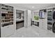 Bright walk-in closet featuring custom white shelving, storage and marble tile at 17515 Drake Ct, Lutz, FL 33559