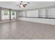 Expansive living room features tile floors, built in shelving and cabinets, and two windows at 1873 Colding Dr, Ruskin, FL 33570
