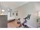Bedroom featuring an exercise bike, a bed with white linens, ceiling fan, and wood flooring at 2411 W Horatio St # 526, Tampa, FL 33609