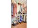 Walk-in closet with shelving racks full of folded and hanging clothes plus a wood floor at 2411 W Horatio St # 526, Tampa, FL 33609