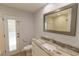 Updated bathroom features a granite countertop, framed mirror, and access to the screened-in pool area at 2505 Buckhorn Run Dr, Valrico, FL 33596
