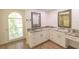 Bathroom with double vanity, granite countertops, decorative mirrors, and natural light from arched window at 2505 Buckhorn Run Dr, Valrico, FL 33596