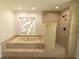 Bright bathroom featuring a tiled shower and a large bathtub with a unique stained glass window at 2505 Buckhorn Run Dr, Valrico, FL 33596