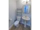 Cozy half bathroom features a pedestal sink, decorative mirror, and wood-look flooring at 2505 Buckhorn Run Dr, Valrico, FL 33596