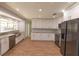 Modern kitchen with granite countertops, stainless steel appliances, white cabinets, and wood flooring at 2505 Buckhorn Run Dr, Valrico, FL 33596