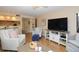 Bright living room with wood-look flooring features entertainment center and comfortable seating, creating a relaxing atmosphere at 2593 Countryside Blvd # 7204, Clearwater, FL 33761