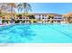 Community outdoor pool with poolside furniture, lush landscaping and multi-story condos at 2593 Countryside Blvd # 7204, Clearwater, FL 33761