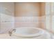Elegant bathtub with tile surround and shuttered windows, perfect for a relaxing spa-like experience at 2704 Chambray Ln, Tampa, FL 33611