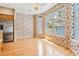 Dining area filled with windows, hardwood floors, and patterned wallpaper at 2704 Chambray Ln, Tampa, FL 33611
