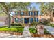 Beautiful two-story brick home with blue shutters, green lawn, and mature trees at 2704 Chambray Ln, Tampa, FL 33611