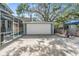 Detached garage with large concrete driveway surrounded by lush landscaping at 2704 Chambray Ln, Tampa, FL 33611