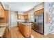 Bright kitchen with wood cabinets, stainless steel appliances, island with stove and ample counterspace at 2704 Chambray Ln, Tampa, FL 33611