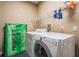 Functional laundry room with washer, dryer, storage shelves and space for cleaning supplies at 2704 Chambray Ln, Tampa, FL 33611