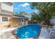 Sparkling in-ground pool with waterfall feature, brick trim, and ample lounge space at 2718 W Leila Ave, Tampa, FL 33611