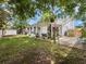 View of the backyard with lawn and screened patio including brick pavers and landscaping at 2720 Wiltshire Ave, Palm Harbor, FL 34685