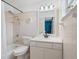 Bright bathroom featuring tiled walls, a shower-tub combo, and a pristine white vanity at 2720 Wiltshire Ave, Palm Harbor, FL 34685