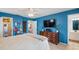 Charming bedroom with blue walls, TV and dresser with a view into ensuite bathroom at 2720 Wiltshire Ave, Palm Harbor, FL 34685