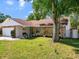 This home features stone accents and a well-manicured lawn at 2720 Wiltshire Ave, Palm Harbor, FL 34685